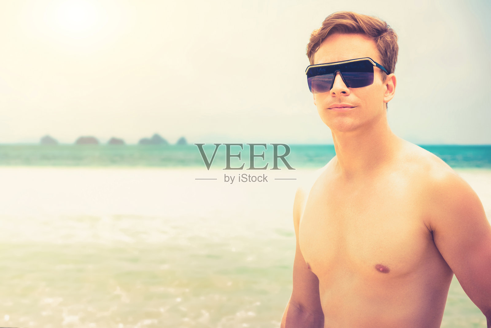 帅气的男人戴着太阳镜在夏天的海滩上照片摄影图片