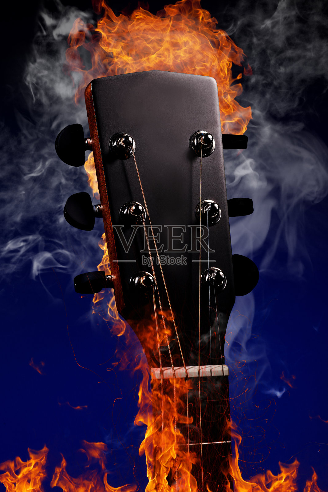 吉他颈与弦在火和烟的蓝色背景。有复制空间的乐器广告照片。模型。照片摄影图片
