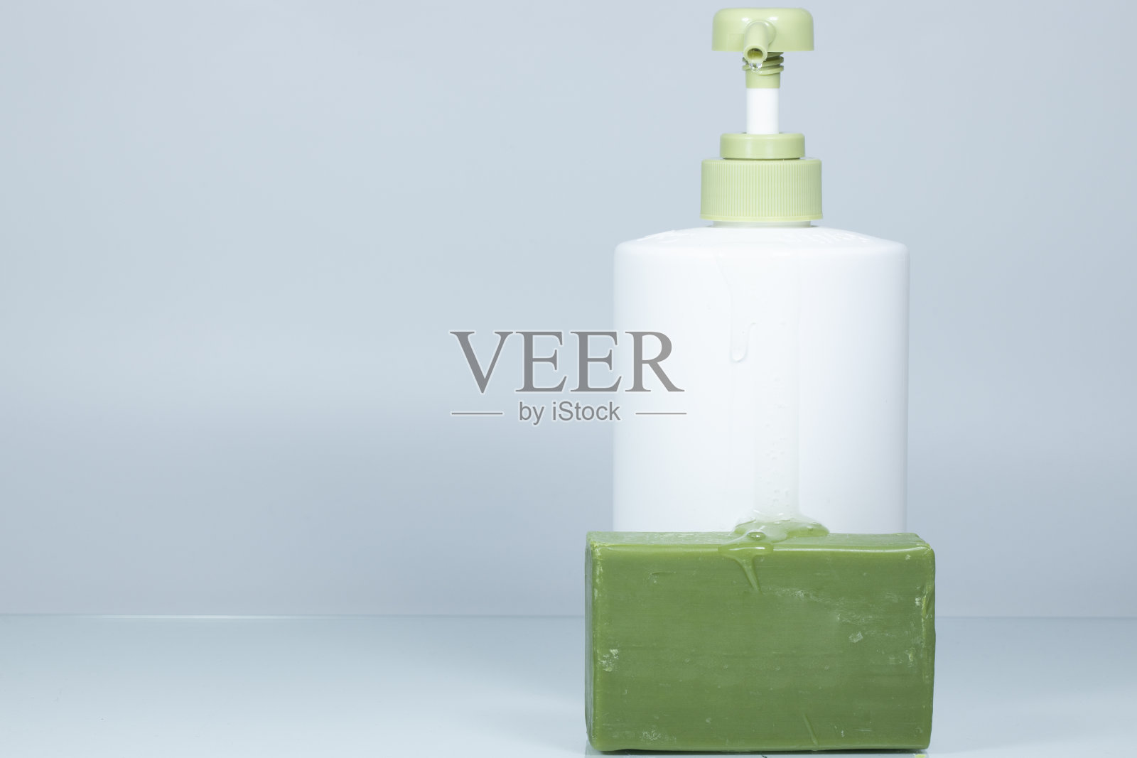 绿色的橄榄油液体肥皂和固体肥皂。在白色背景上拍摄。关闭了。照片摄影图片