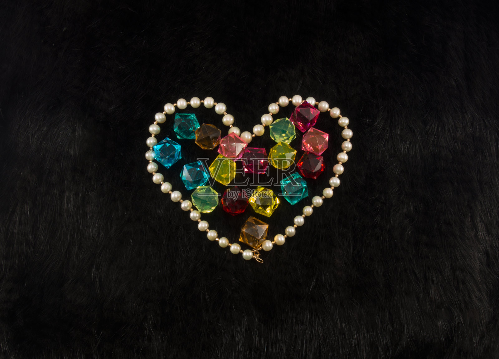 白色珍珠心与颜色宝石内在黑色毛皮背景照片摄影图片