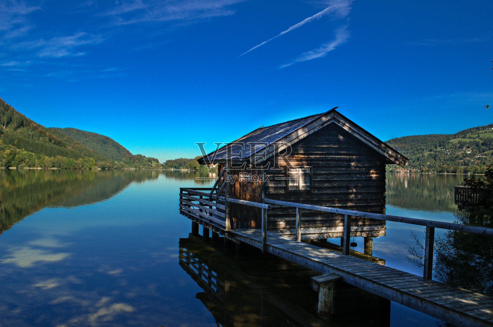 湖上的木屋，绿树成荫，天空湛蓝照片摄影图片