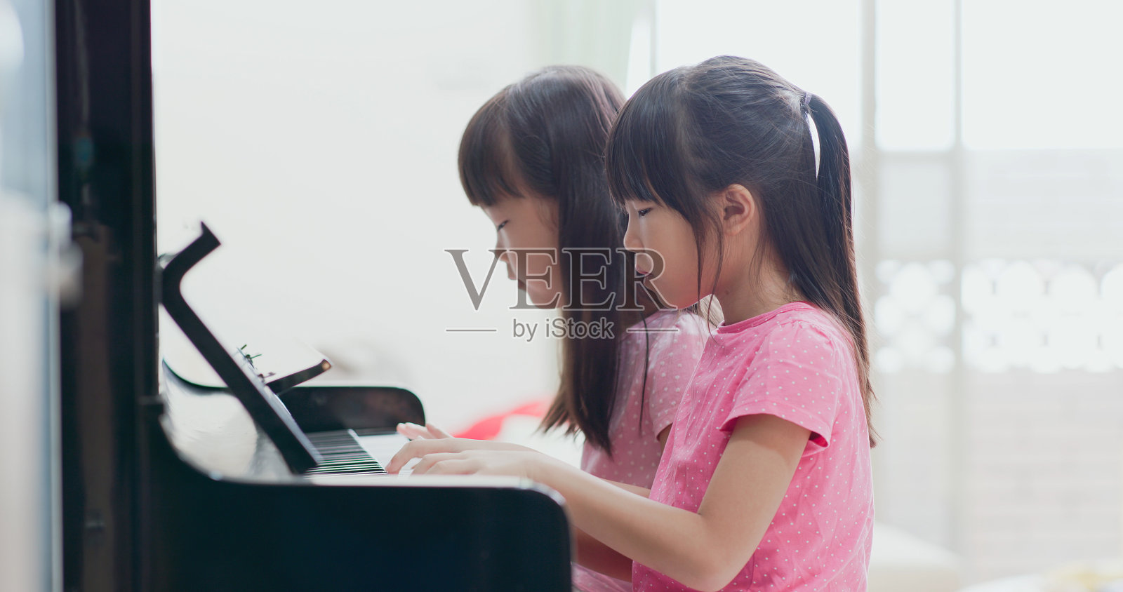 两个亚洲女孩弹钢琴照片摄影图片