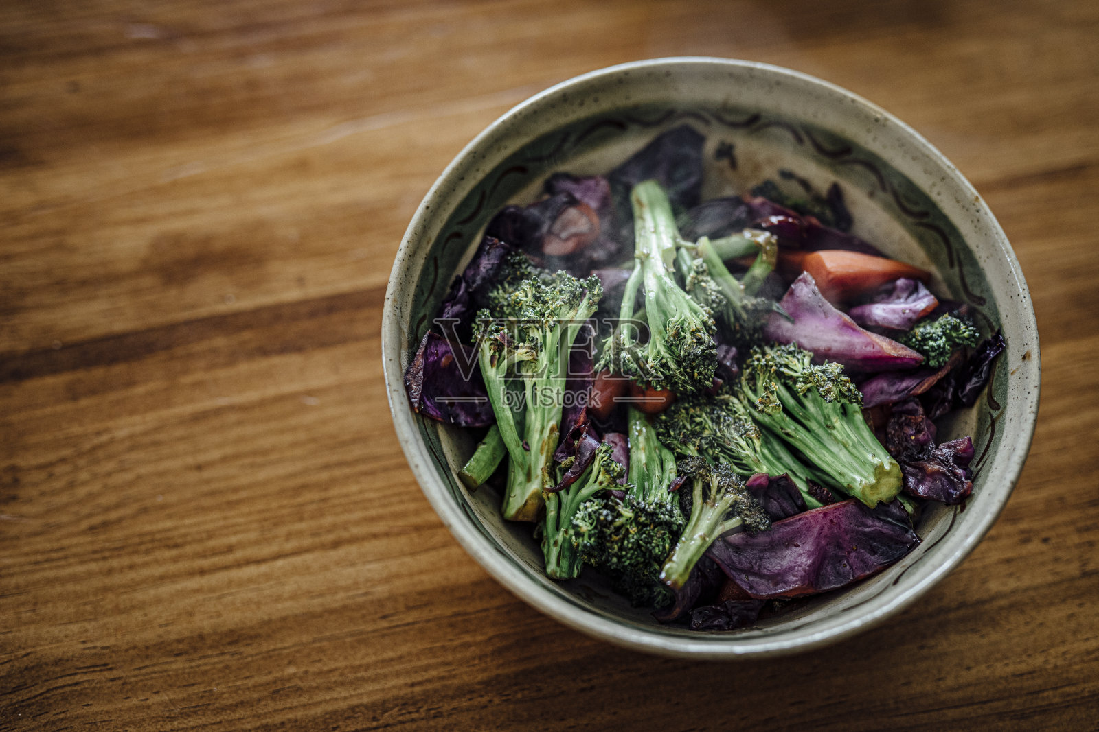 新鲜的花椰菜和紫甘蓝蒸后与亚洲香料一起食用。健康的素食食谱。照片摄影图片