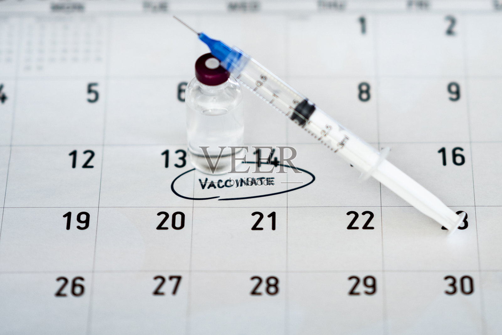 日历上的疫苗瓶和注射器上有预定的接种预约照片摄影图片