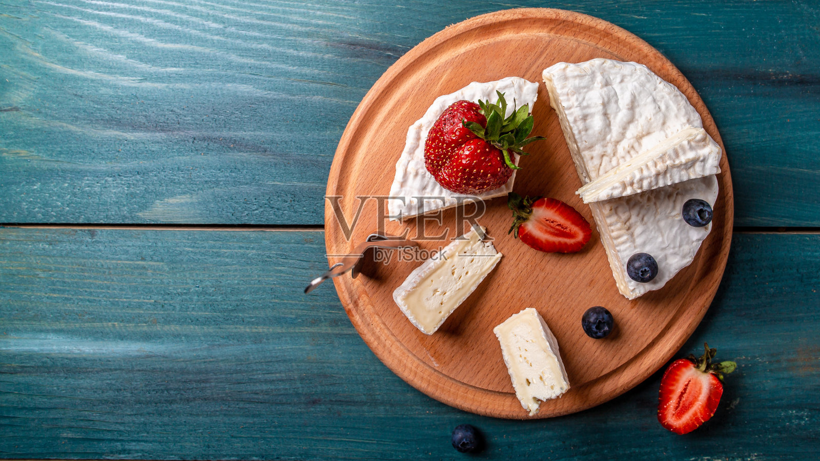 布里奶酪。卡蒙伯尔的奶酪。新鲜的布里干酪和一片带浆果的木板。意大利、法国奶酪。食品配方的背景。空间的文本。俯视图照片摄影图片