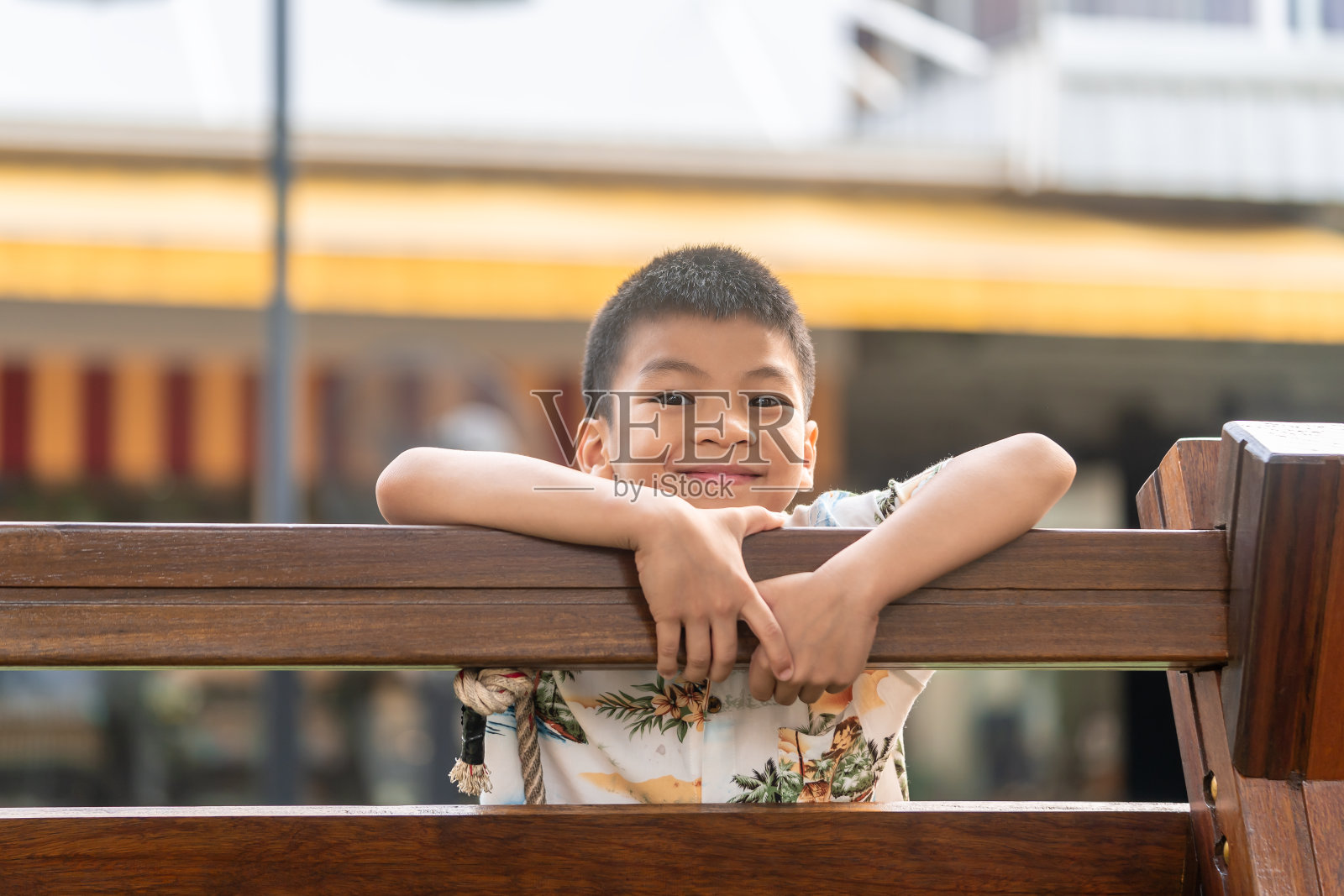 健康的亚洲男孩爬到一个木制游乐场的顶部在公共公园为健康和快乐的儿童概念照片摄影图片