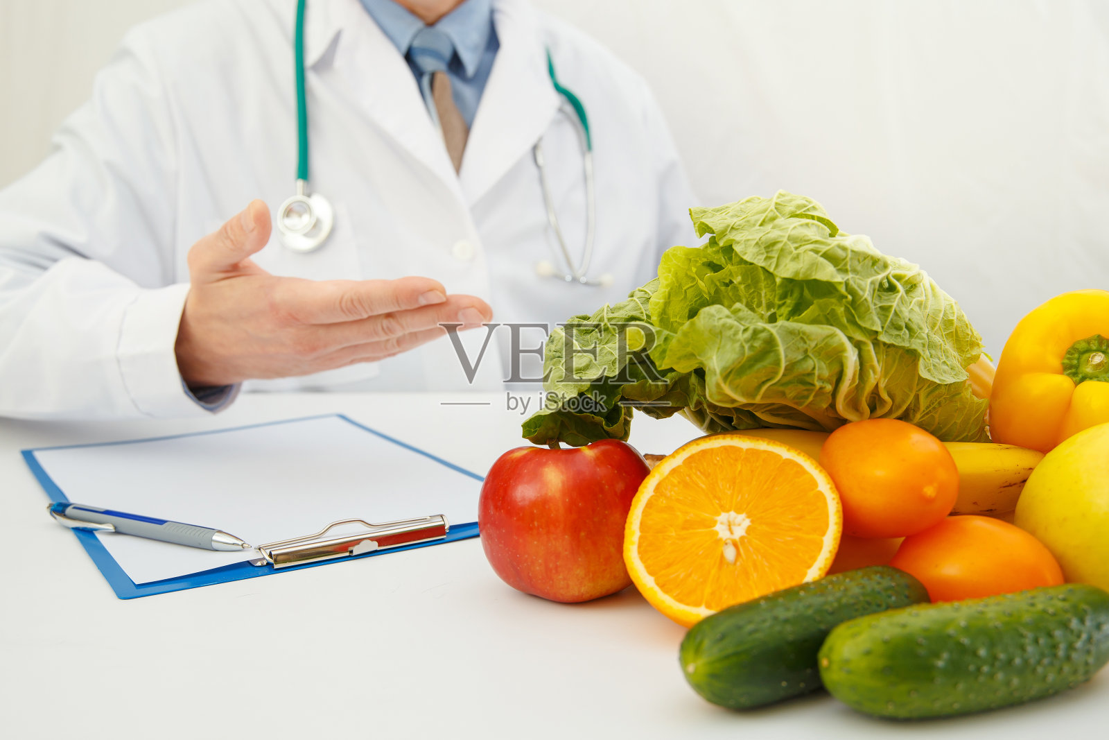 营养师医生讨论饮食。桌子上有水果和蔬菜。照片摄影图片