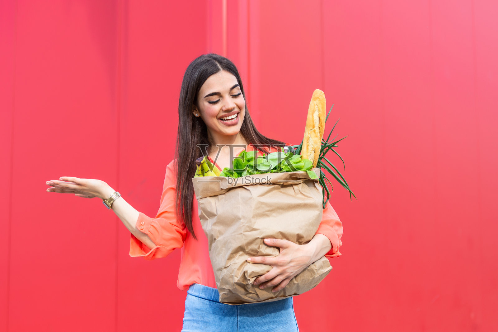 一个年轻女子拿着一个装满蔬菜的购物袋，一个年轻女子拿着一个装满新鲜蔬菜的购物袋。饮食健康饮食理念照片摄影图片