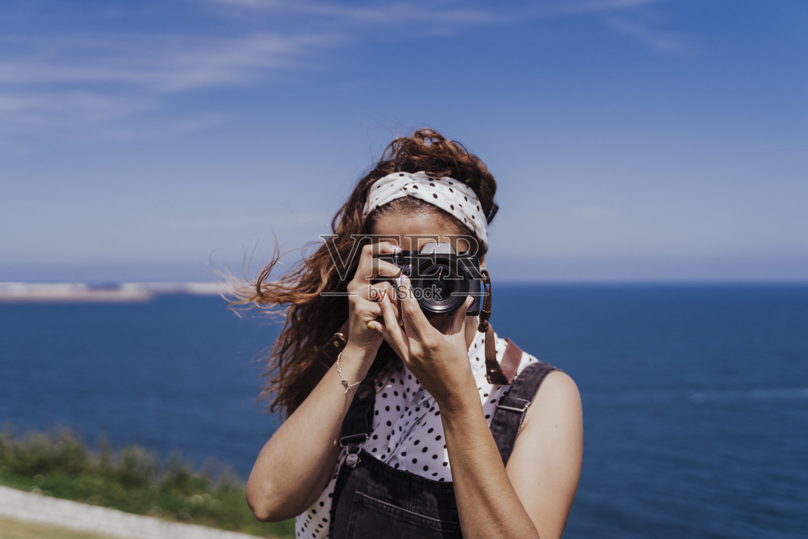 年轻的白种女游客户外与反光镜相机在一个风和阳光明媚的一天。生活方式，旅游和夏季时间照片摄影图片