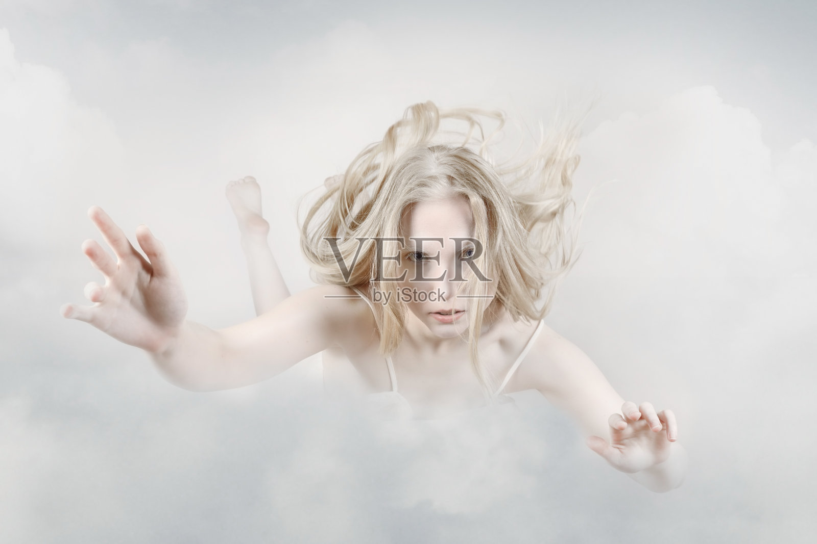 年轻女子在天空中飘过云朵。灵魂放松照片摄影图片