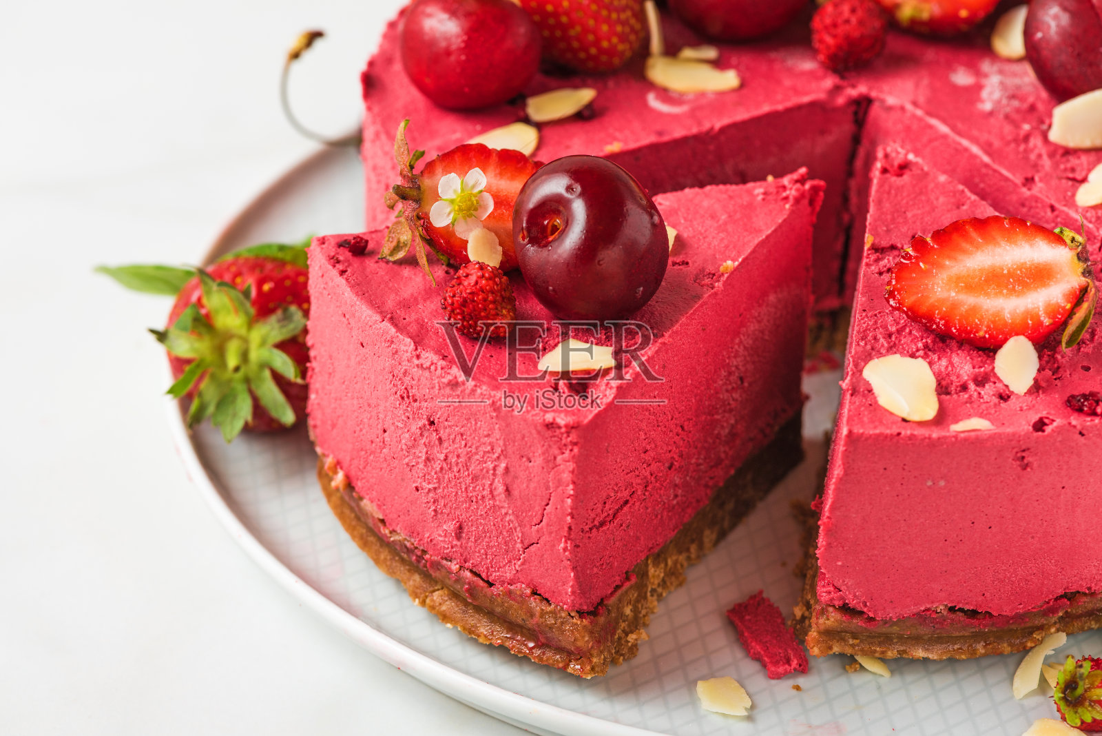 切片的浆果素奶酪蛋糕或蛋糕与新鲜的樱桃和草莓在一个盘子。关闭了。健康的素食餐后甜点照片摄影图片