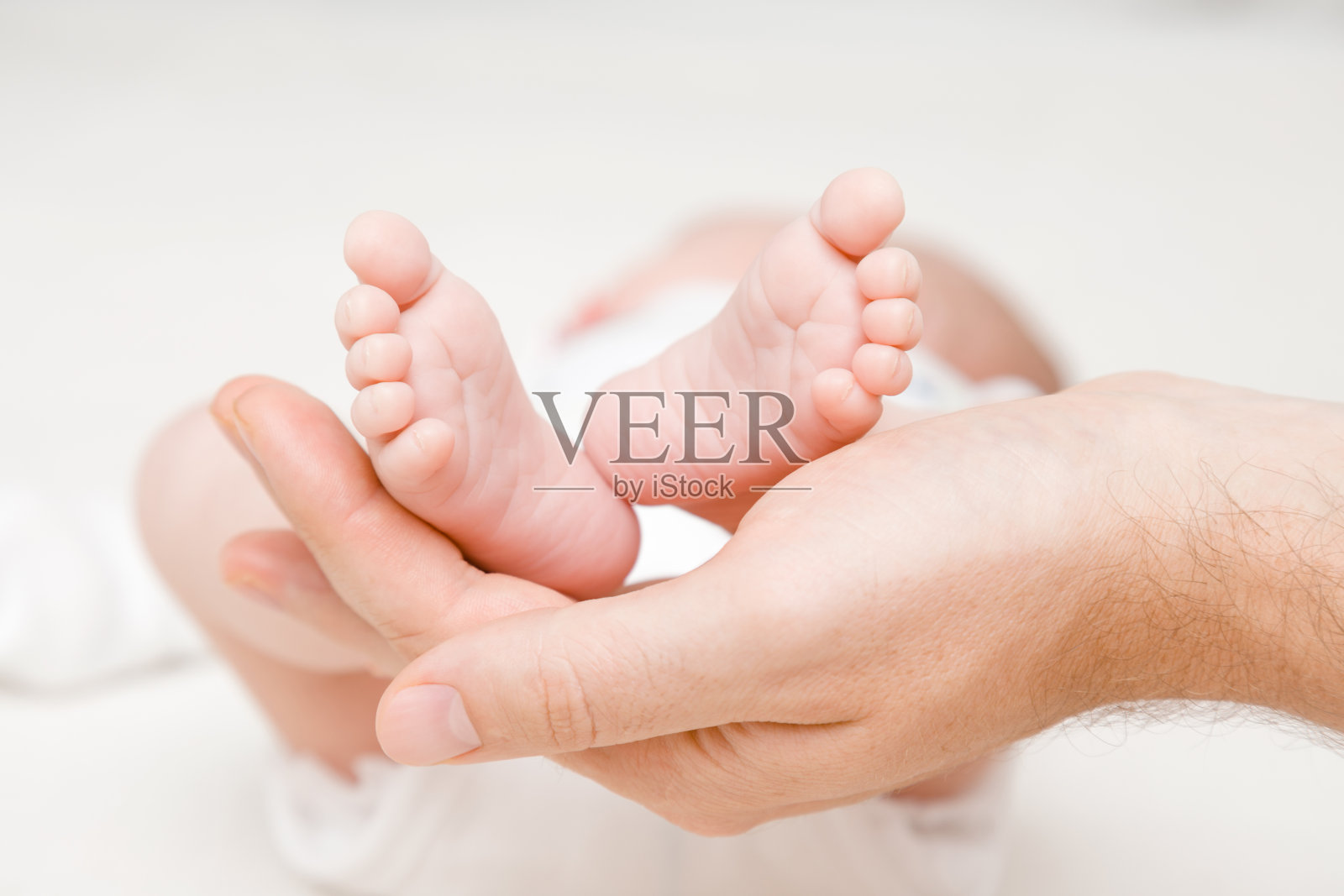 新生的可爱的脚在年轻的父亲的手掌。可爱的、情感的时刻。特写镜头。前视图照片摄影图片