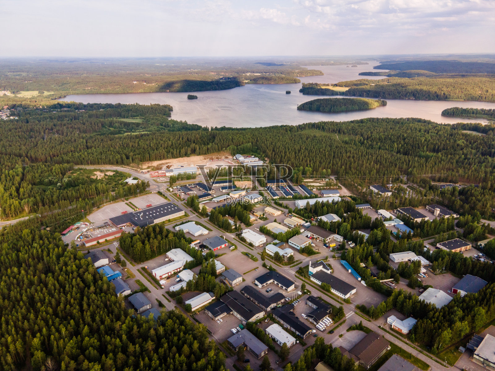 鸟瞰图的蓝色湖泊与阳光森林在芬兰拉普兰。照片摄影图片