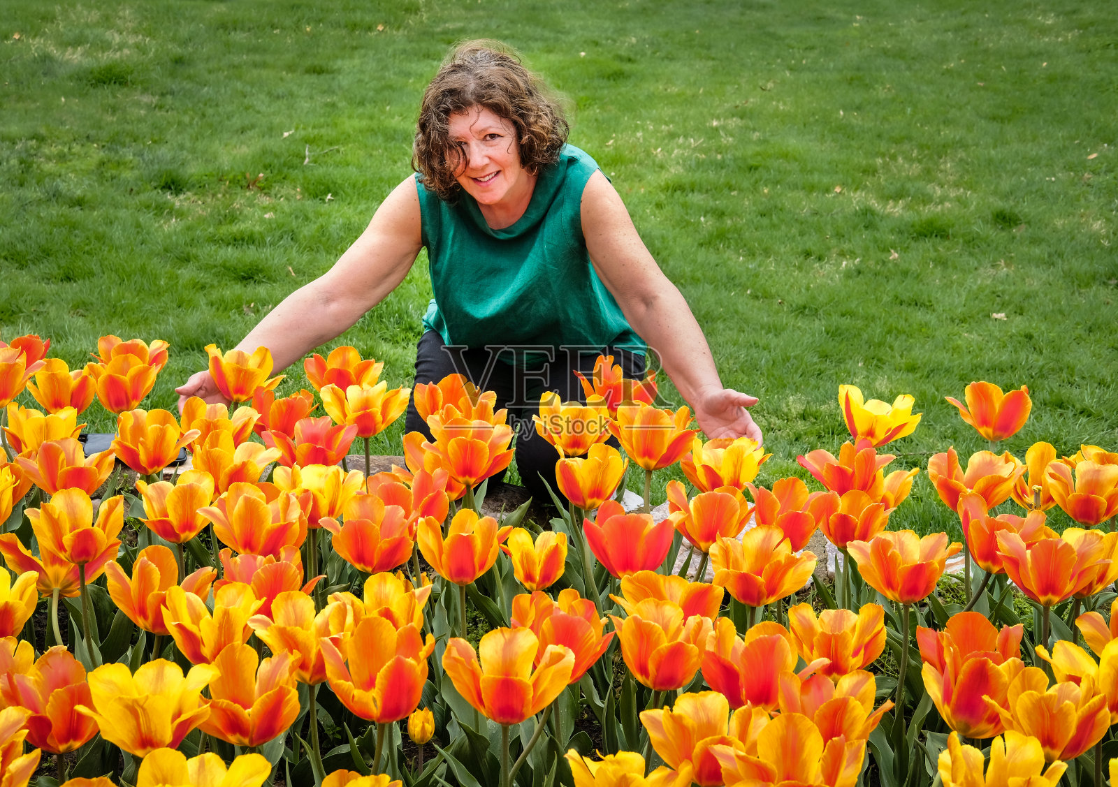 成熟的女人在公园里盛开着美丽的郁金香照片摄影图片