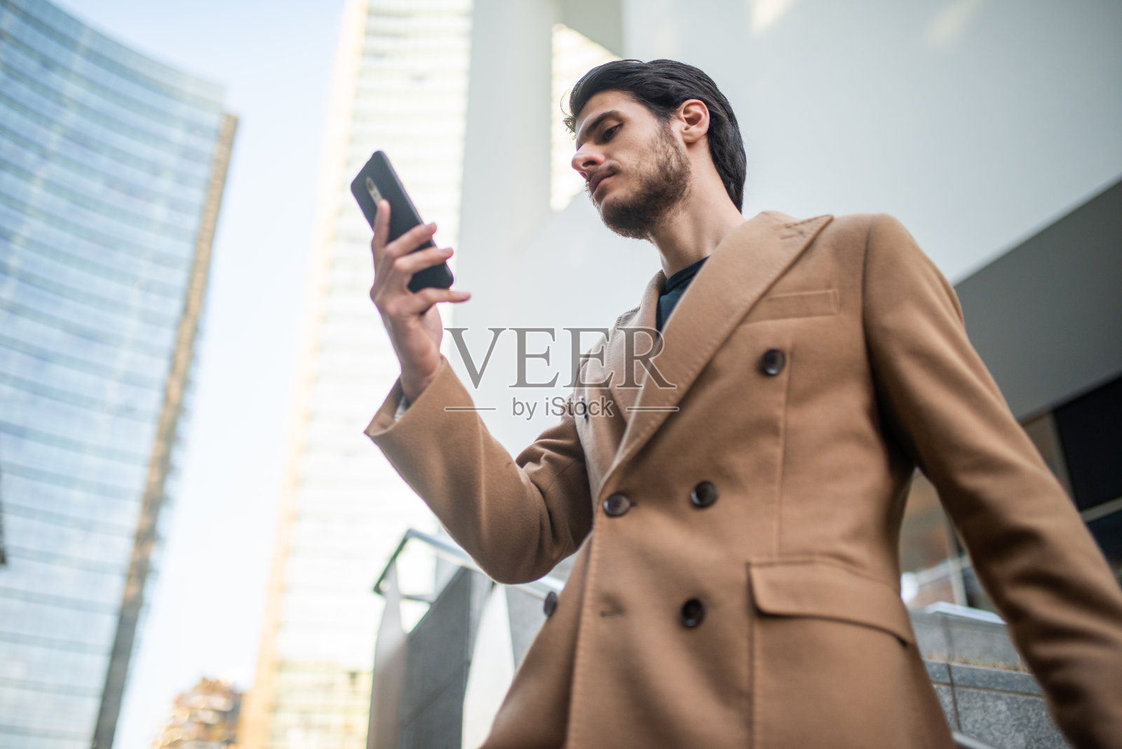 一个年轻人在户外用手机照片摄影图片