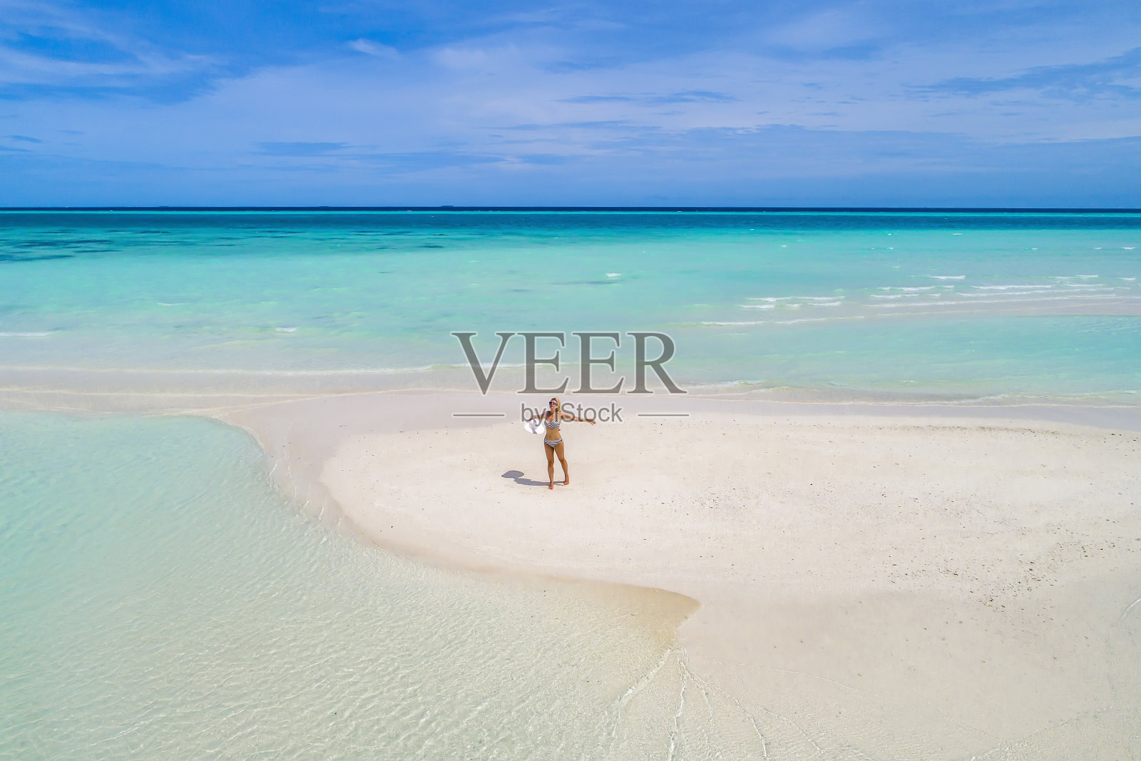 夏日假日的时尚概念——晒黑的女孩戴着太阳帽在沙滩上白沙滩上拍摄。俯视图从无人机。鸟瞰躺在马尔代夫海滩上晒太阳的苗条女人照片摄影图片