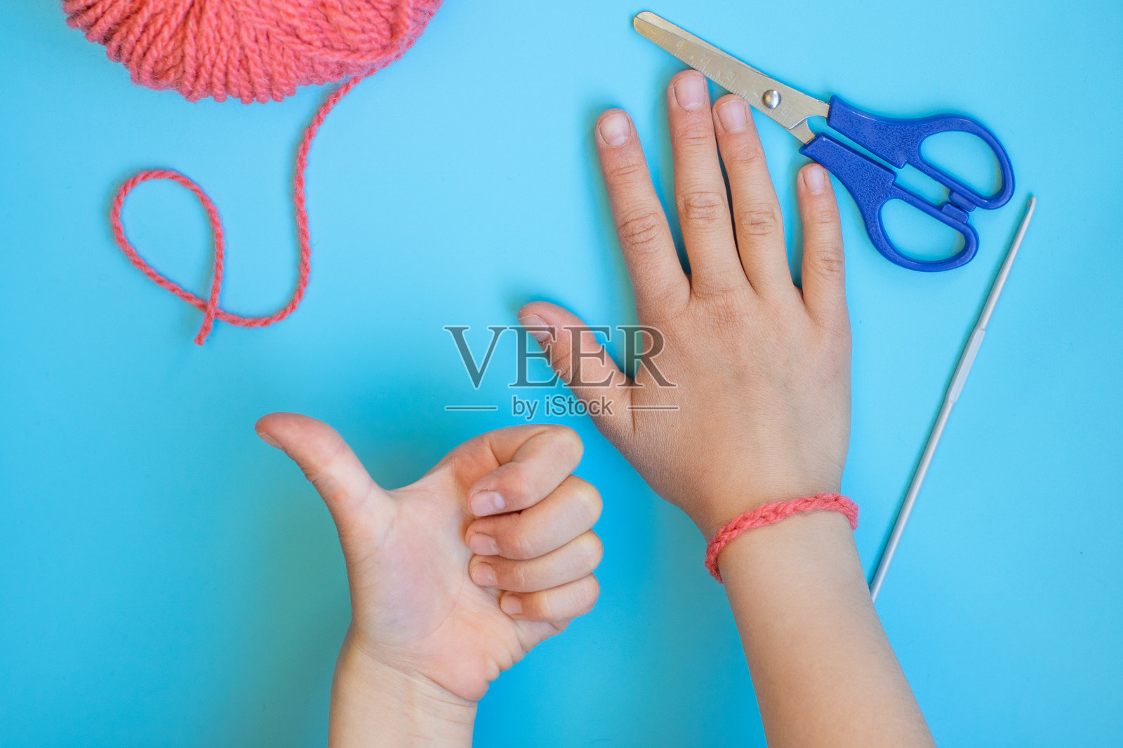 DIY一步一步的指导孩子如何用纱线编织一个手镯照片摄影图片