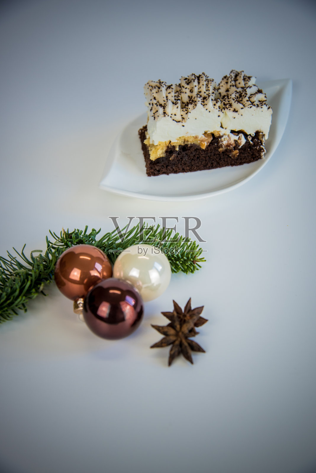 在白色的底座上放一块蛋糕在白色的盘子和圣诞装饰照片摄影图片