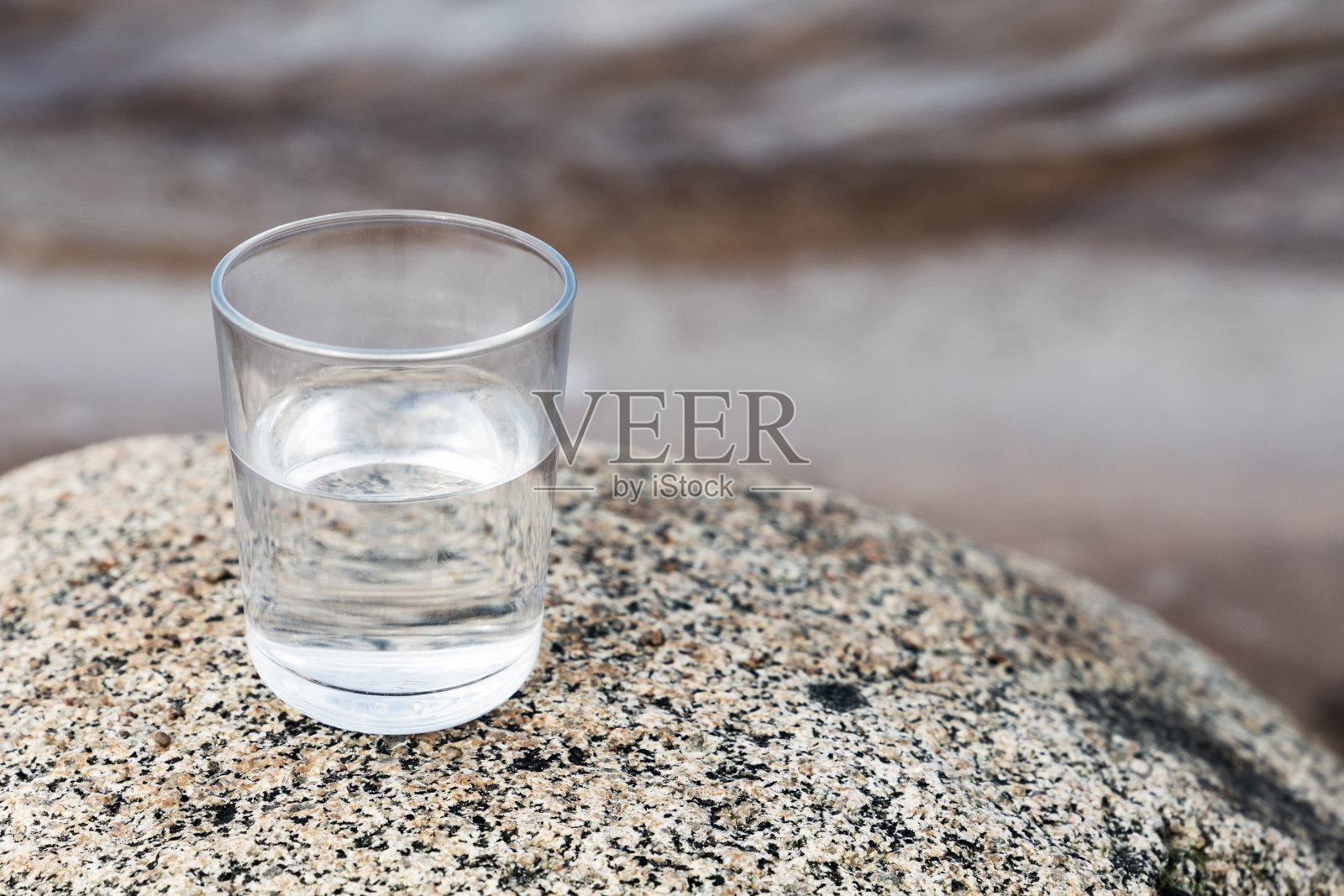 一块石头上放着一杯清澈的水照片摄影图片