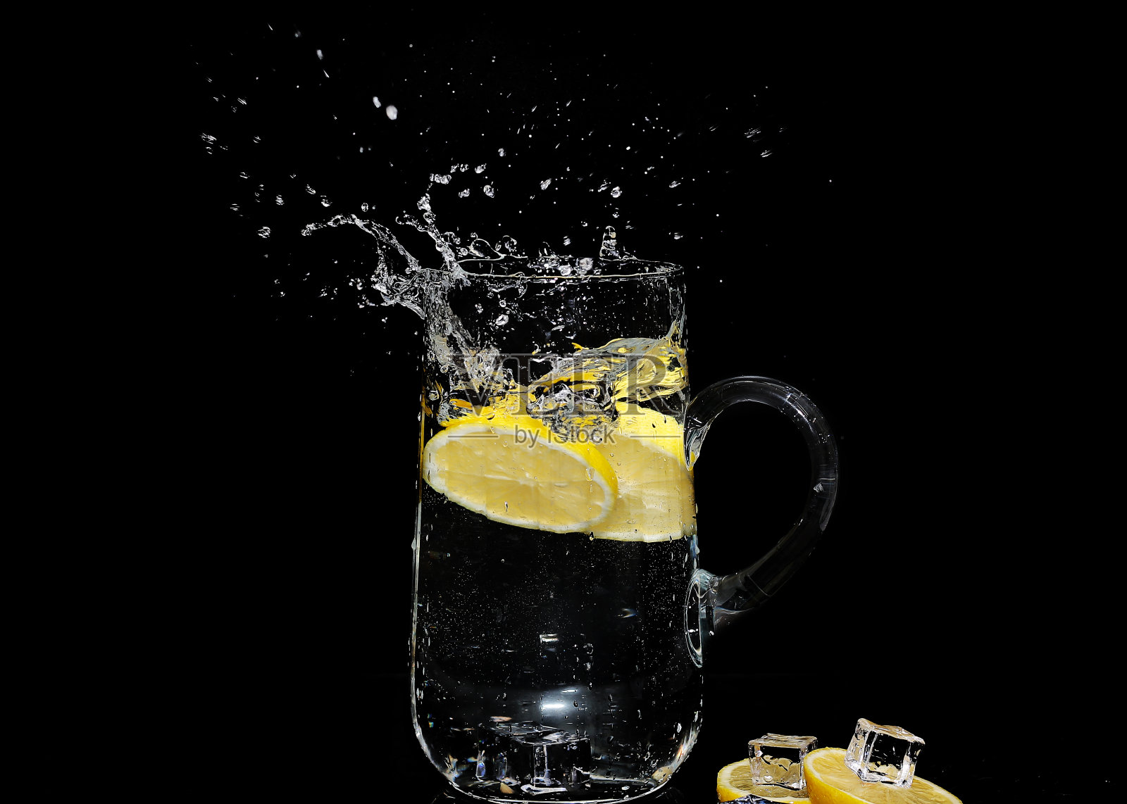 冰水飞溅与柠檬片孤立的黑色背景-高速摄影照片摄影图片