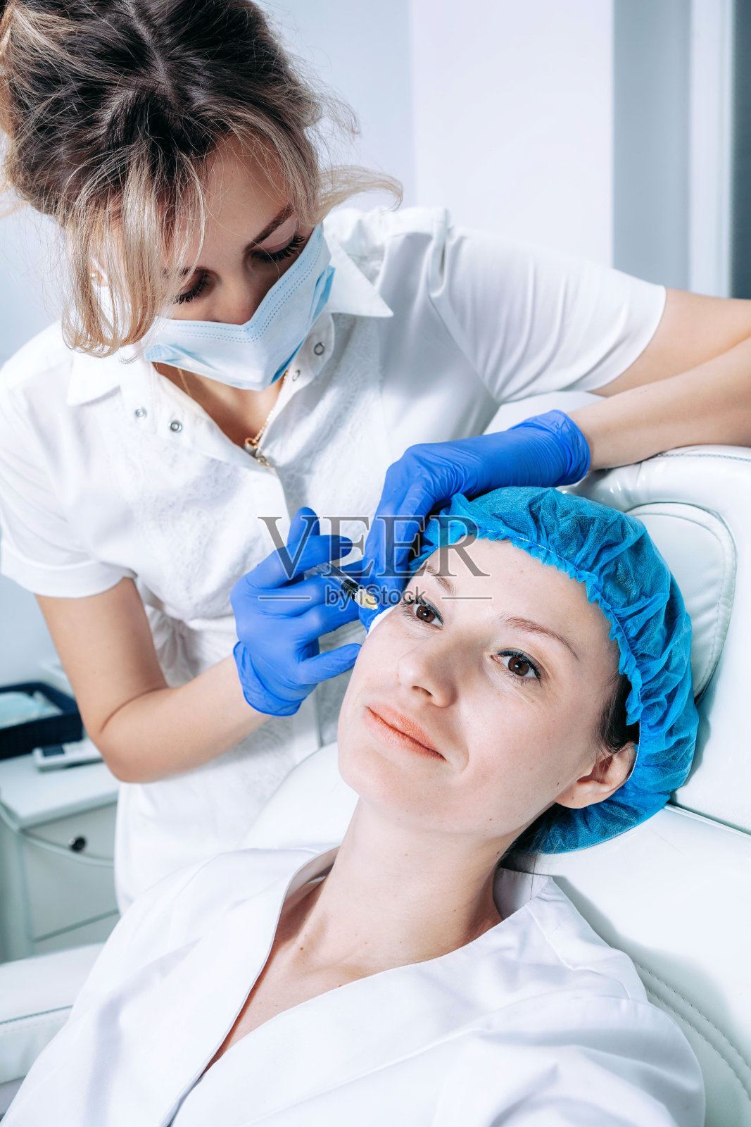 医生美容师在美容院为女性皮肤进行“再生生物活力面部注射”照片摄影图片