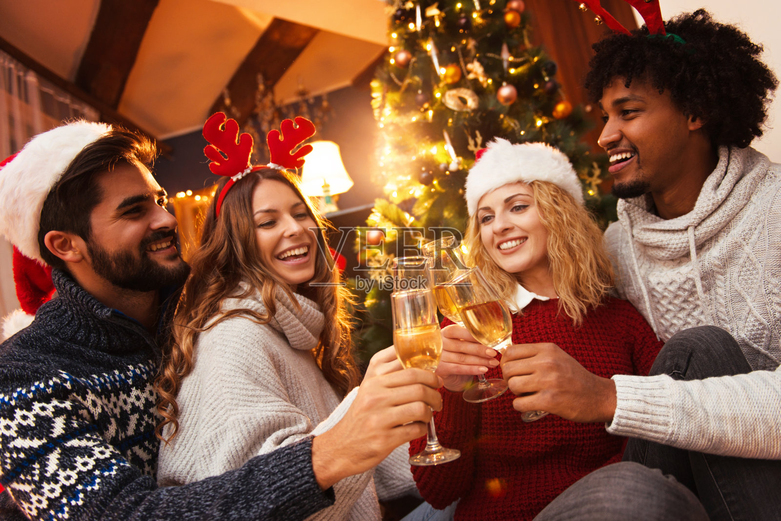 一群朋友在一起享受圣诞节，用香槟欢呼照片摄影图片