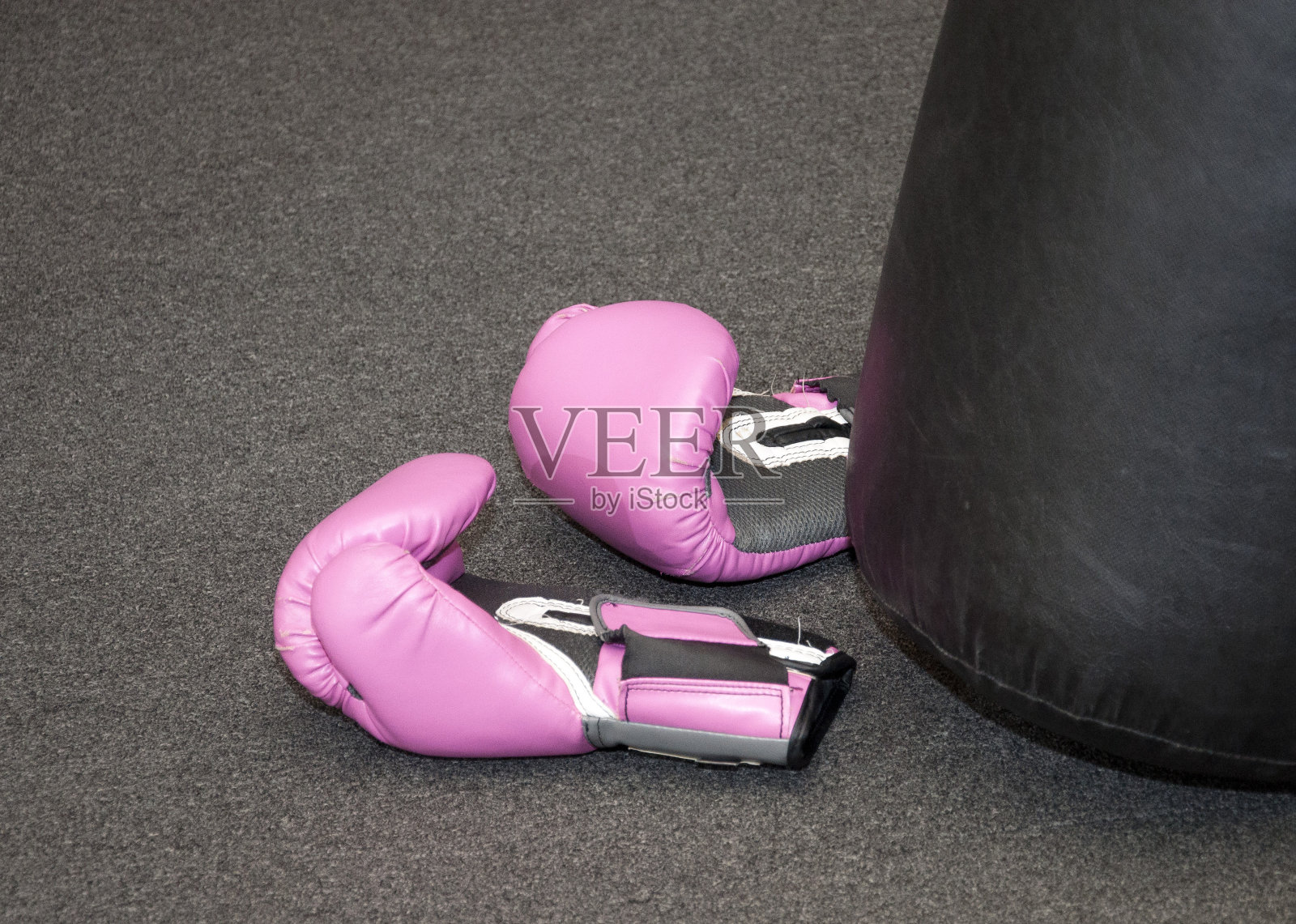 一对粉色拳击手套底部的打击袋照片摄影图片