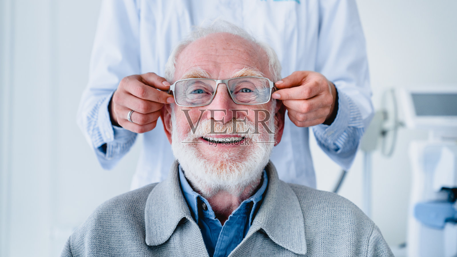 医生给愉快的老年男性病人配眼镜:裁剪照片照片摄影图片