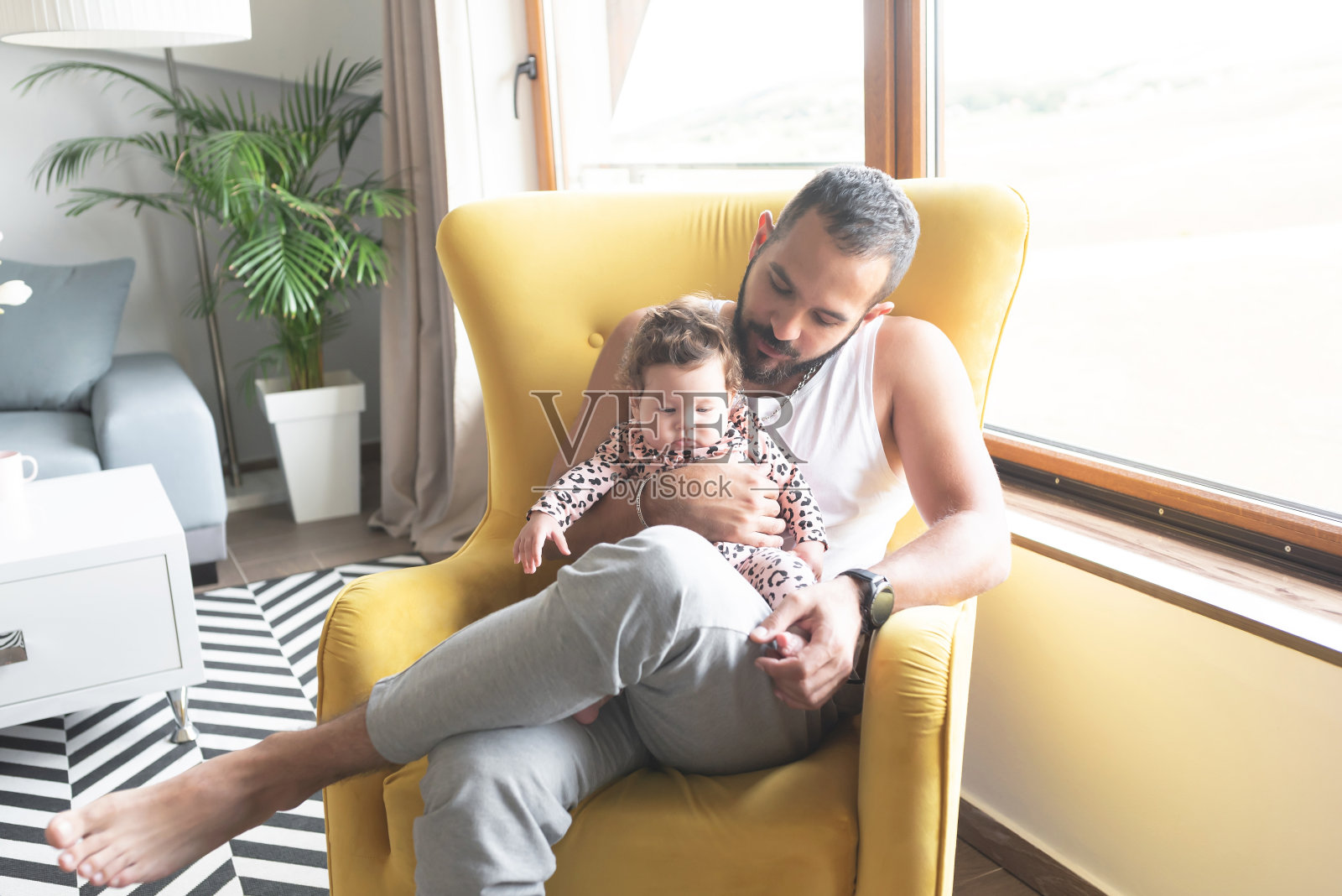 父亲和小女儿坐在家里的扶手椅上照片摄影图片