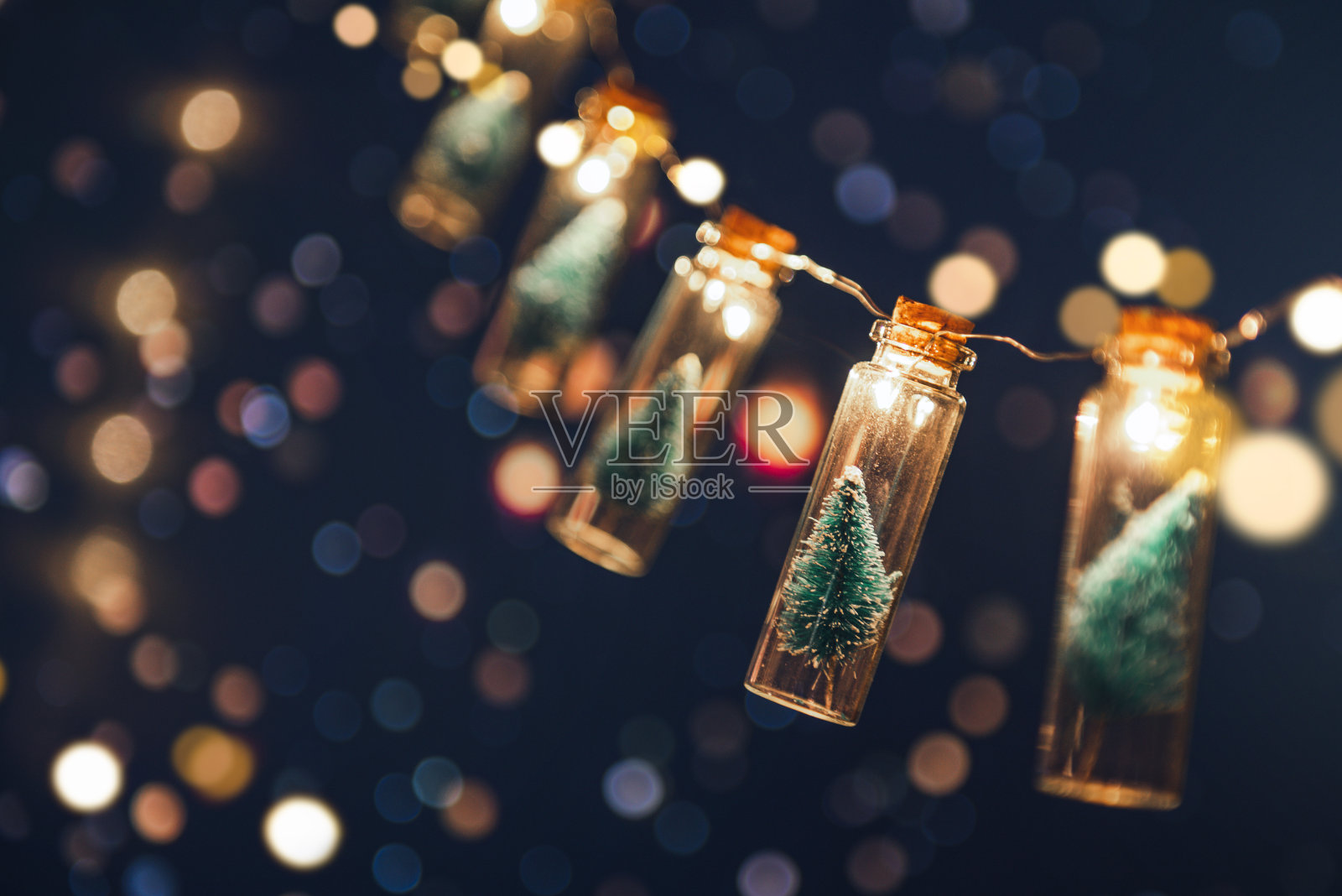 特写，优雅的玻璃罐圣诞树与散景灯背景，圣诞和新年的概念。照片摄影图片