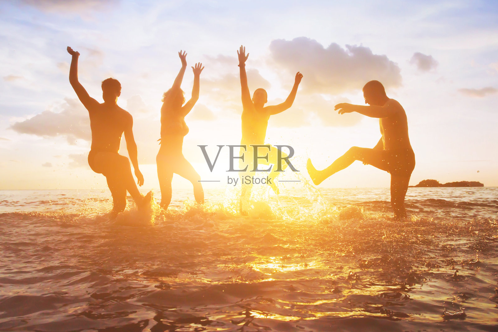 日落时分，一群朋友在水中嬉戏，快乐的人们的剪影照片摄影图片