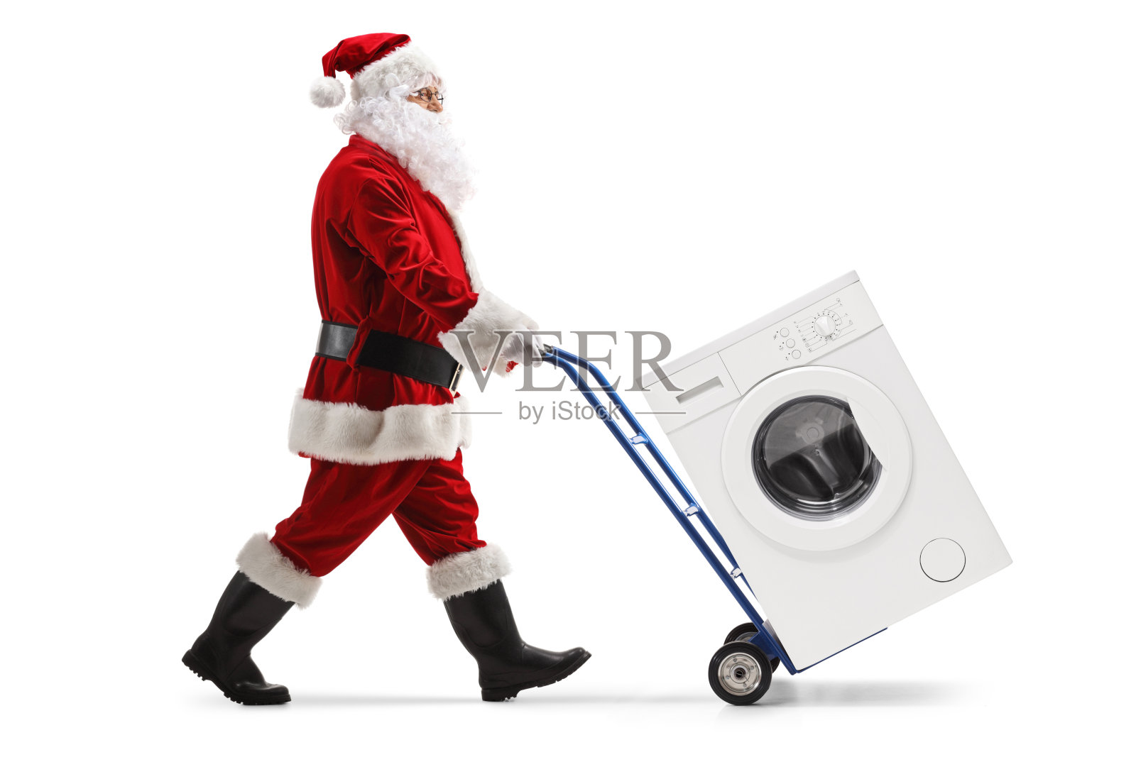 圣诞老人推着手推车上的洗衣机照片摄影图片