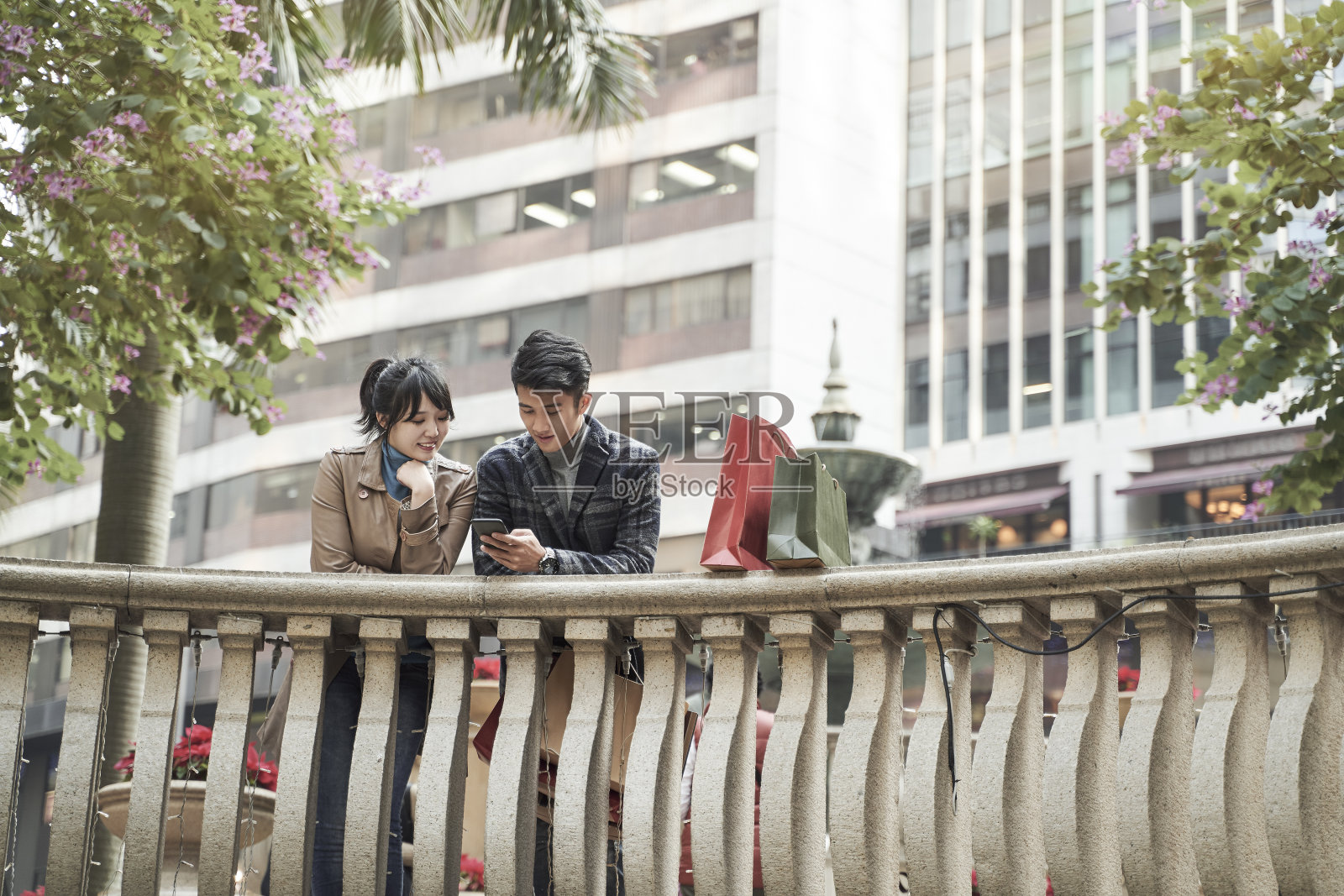 亚洲夫妇在户外使用手机照片摄影图片