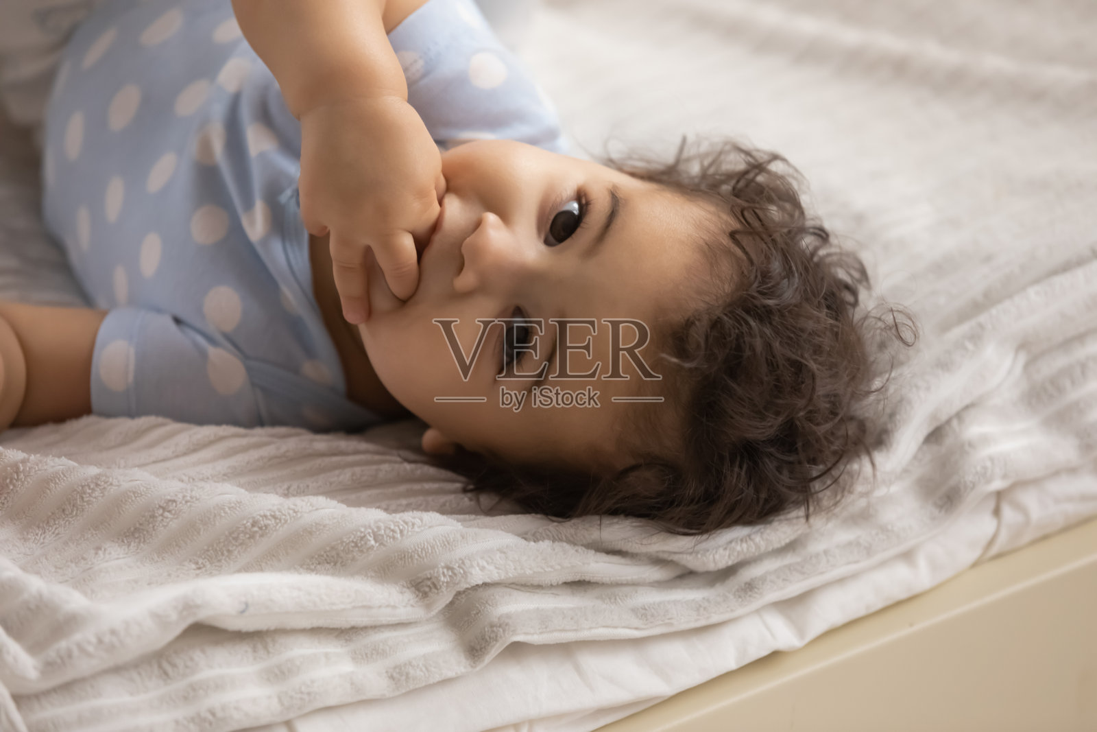 可爱的混血小婴儿躺在舒适的床上照片摄影图片
