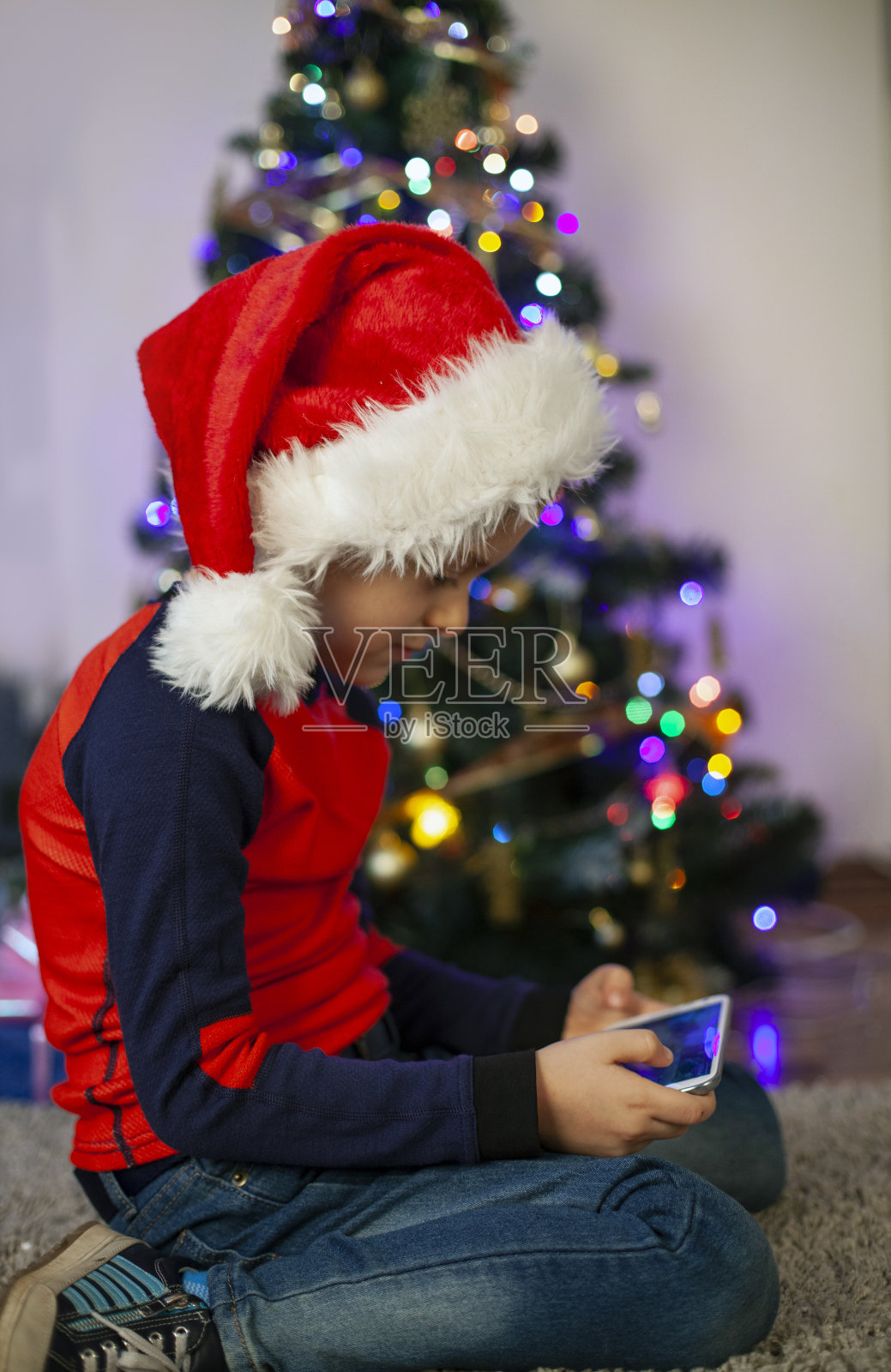 婴儿在圣诞老人的帽子和圣诞礼物照片摄影图片