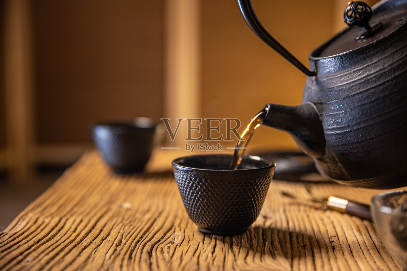 亚洲传统健康饮品，将茶倒入茶杯中照片摄影图片