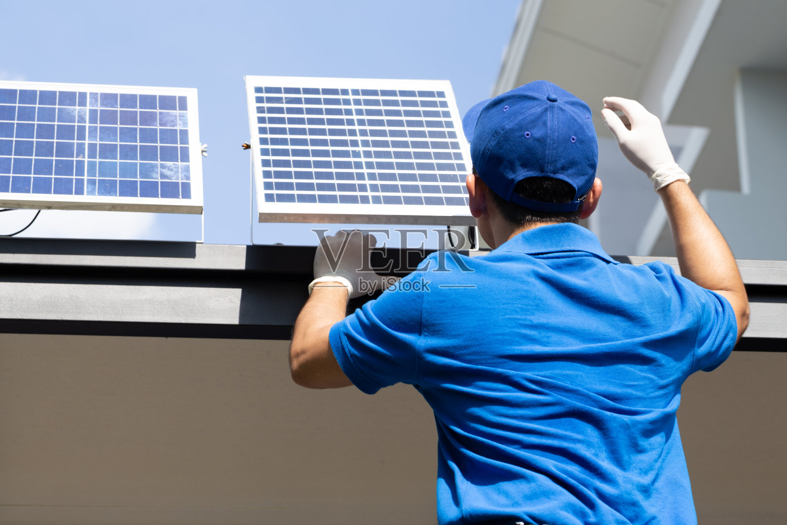 亚洲工人、技术人员正在屋顶上安装用于LED灯的太阳能光伏板。外部太阳能电池系统安装概念照片摄影图片