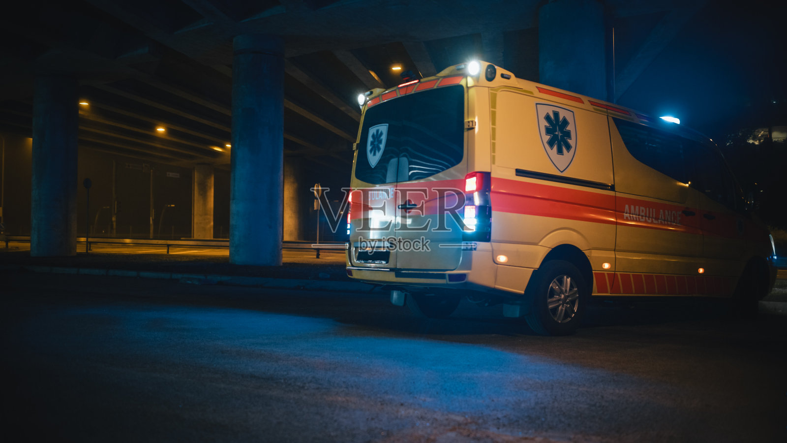一辆载有频闪灯及信号的救护车，连同紧急护理助理，于夜间抵达交通意外现场。急救小组接到紧急呼叫后的反应照片摄影图片
