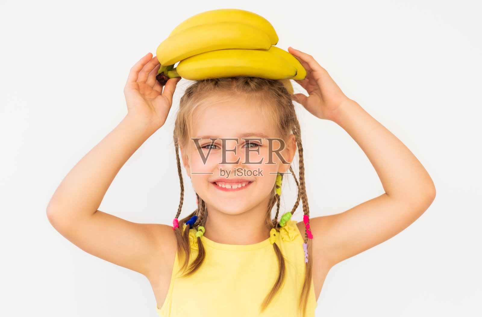 小女孩用细香蕉孤立在白色的照片摄影图片