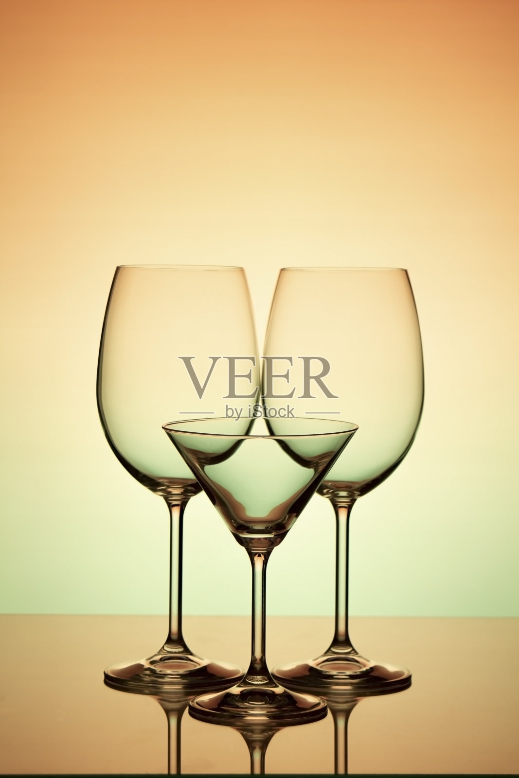 三个葡萄酒杯在橙绿色的背景上照片摄影图片