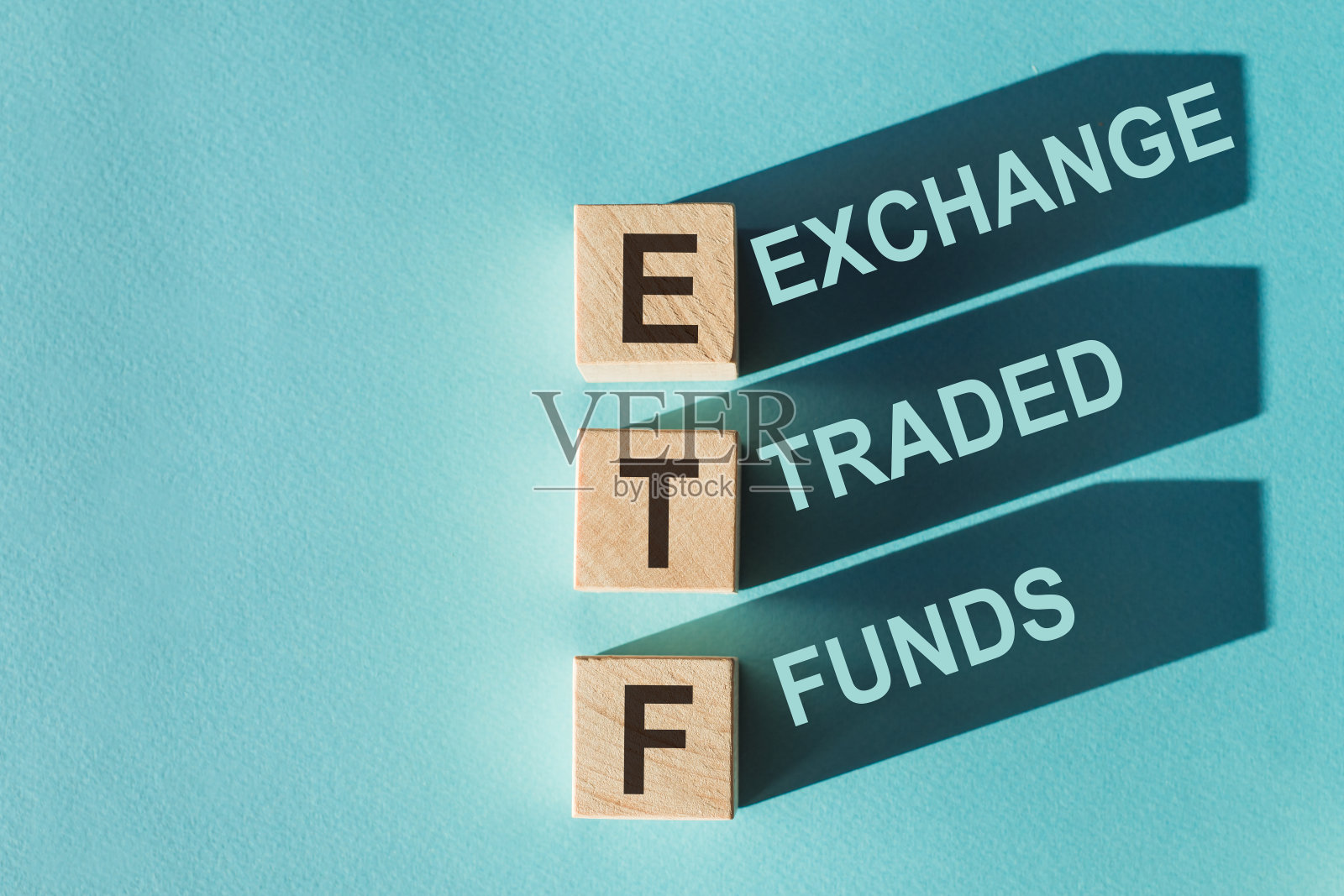 木制立方体构建词ETF(交易所买卖基金的缩写)在浅蓝色背景照片摄影图片