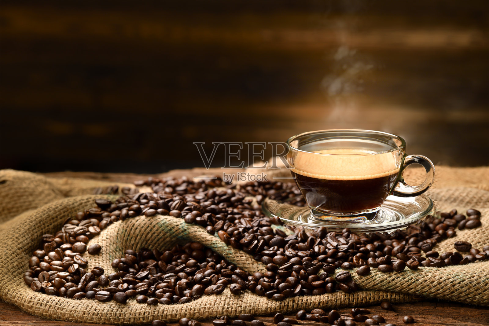 在旧的木制背景上，用粗麻袋装上烟和咖啡豆，一杯一杯的咖啡照片摄影图片