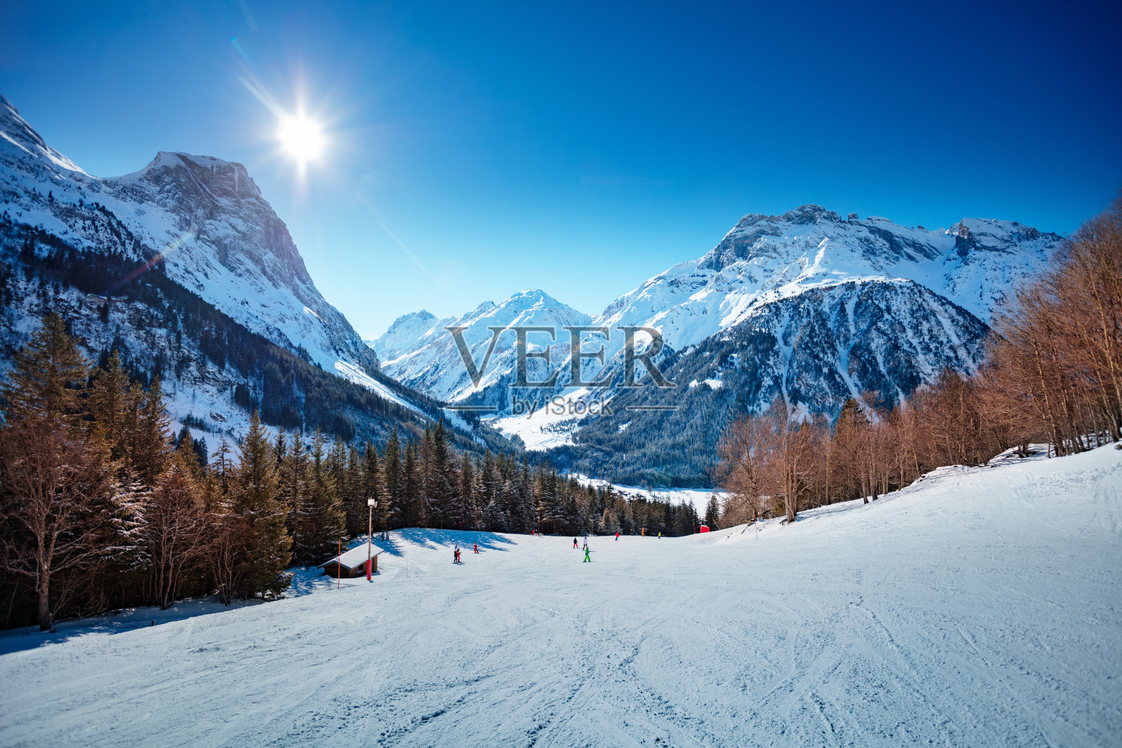 阳光明媚的法国阿尔卑斯山脉上的滑雪道照片摄影图片