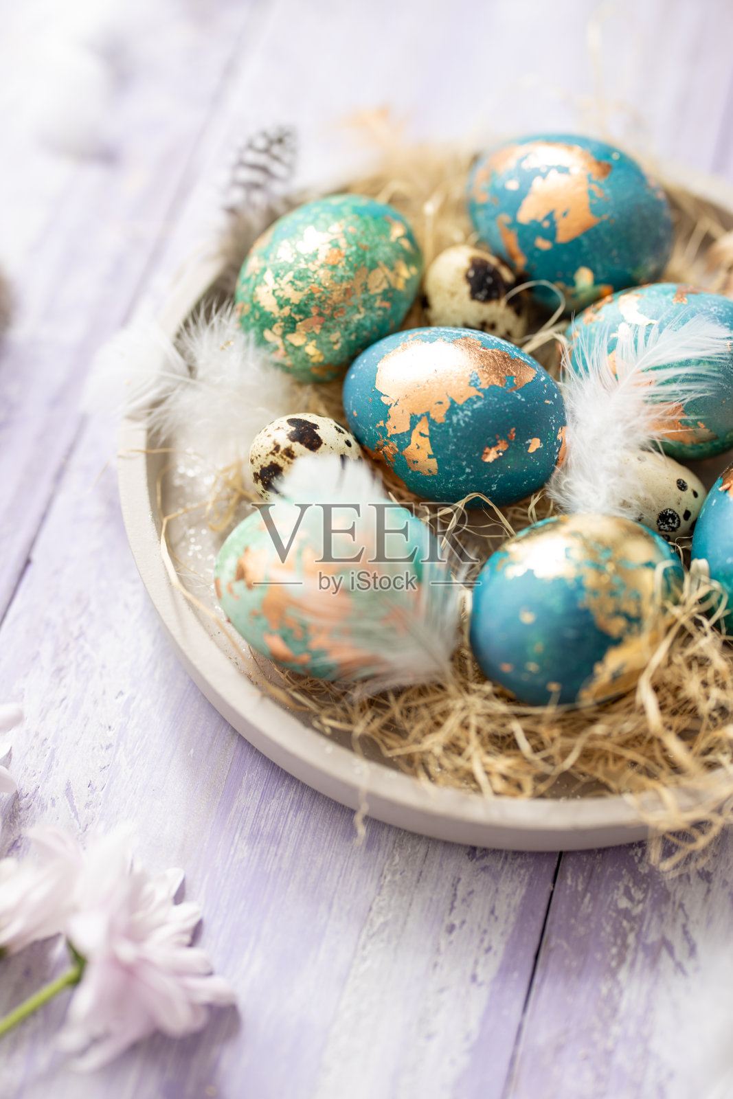 紫色的木头桌子背景上放着蓝色的复活节彩蛋照片摄影图片