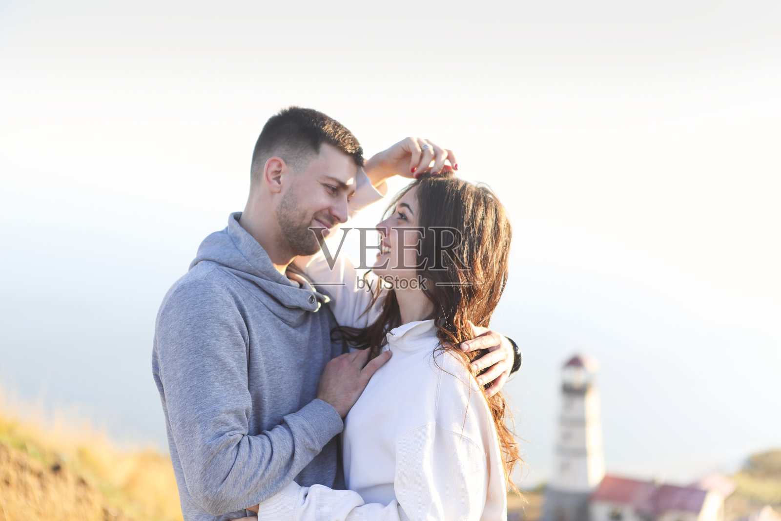 一对浪漫的情侣一起穿着舒适的毛衣在灯塔附近照片摄影图片