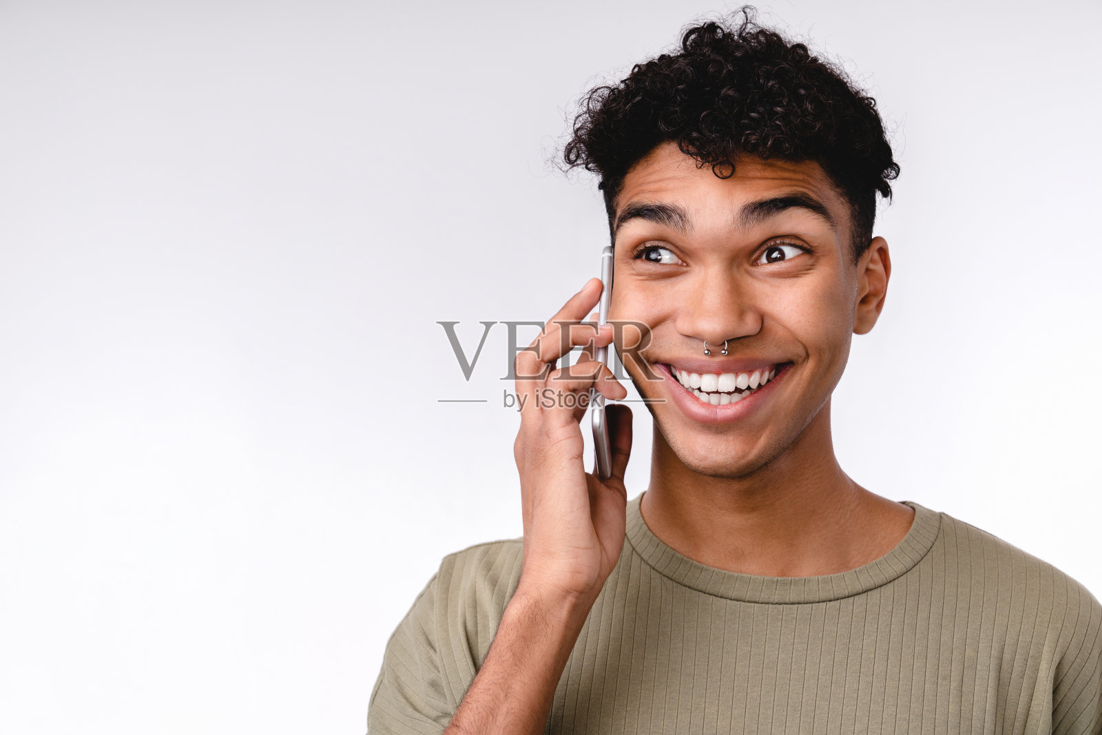 一个年轻的快乐的混血儿男子的特写肖像在电话上孤立的白人照片摄影图片