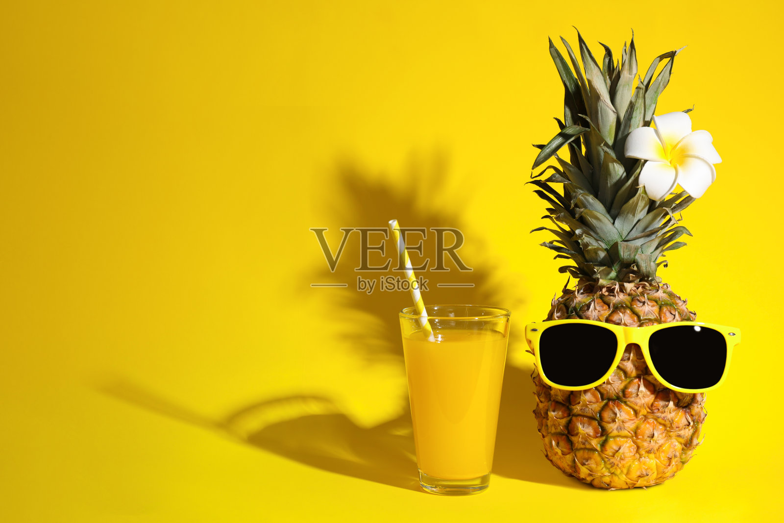 一杯新鲜的菠萝汁和水果与太阳镜在黄色的背景，文字空间照片摄影图片
