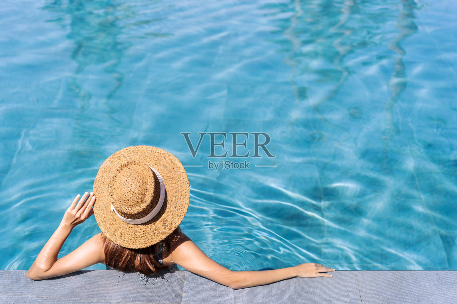 年轻女子旅行者放松和享受热带度假胜地的游泳池，而旅行的暑假，旅游的概念照片摄影图片