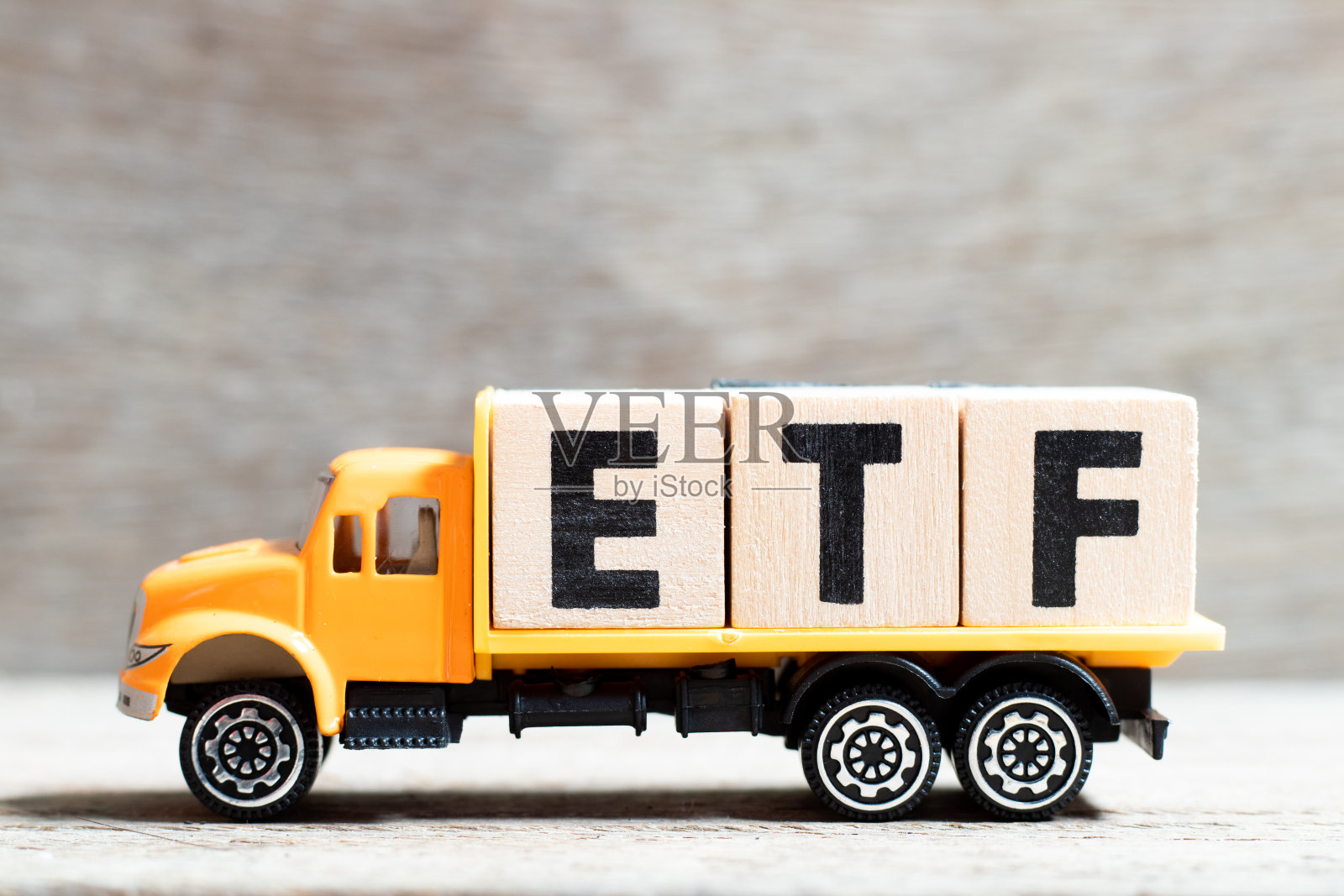 卡车持有字母块在词ETF(简称交易所买卖基金)木背景上照片摄影图片