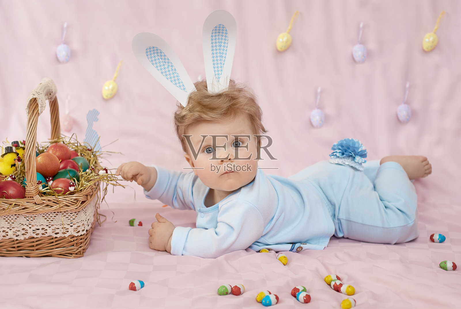 可爱的小婴儿穿着兔子服，穿着粉红色的毯子照片摄影图片
